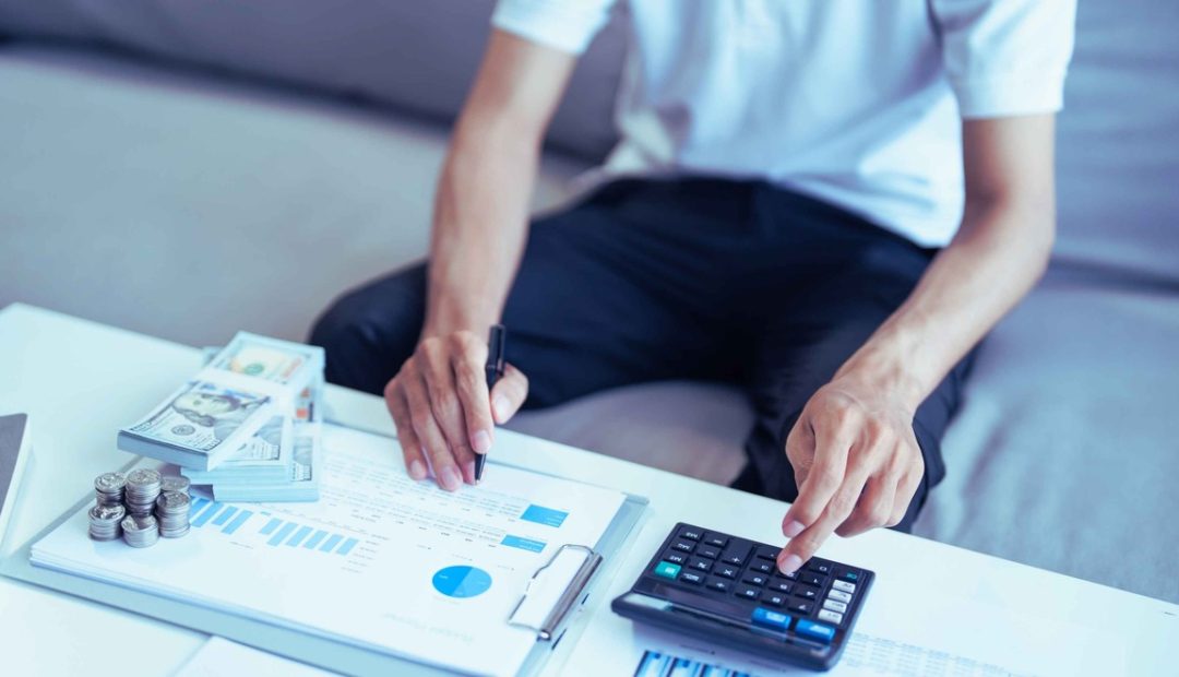 Homme calculant ses dépenses et économies à la maison pour réduire son budget