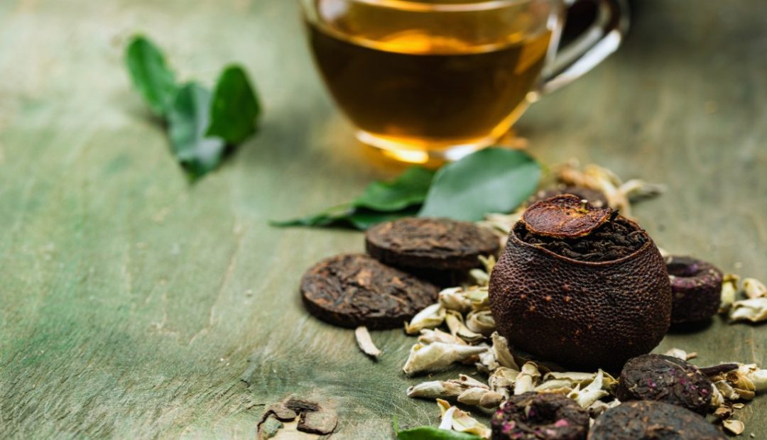 Galettes de thé pu-erh compressé accompagnées d'une tasse infusée