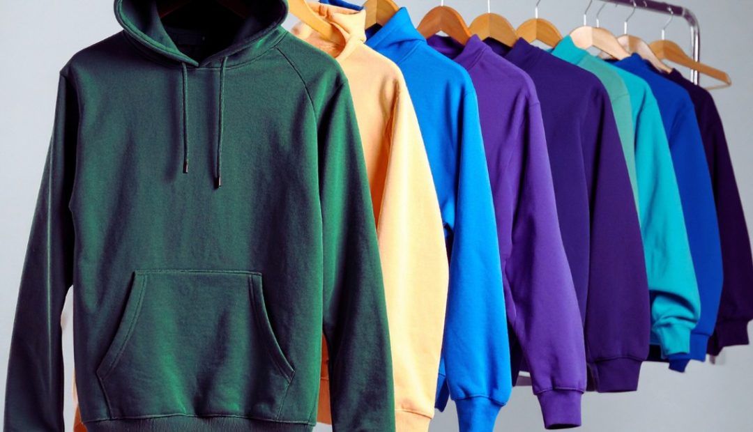 Sweats à capuche de couleurs vives alignés sur un portant de magasin